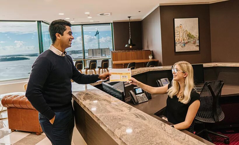 Modern coworking space at Servcorp with staff collecting mail.